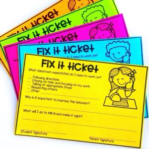 A stack of colorful “Fix it Ticket” classroom forms with cartoon children, designed as part of a classroom management plan, listing behaviors to improve like following directions and staying on task, plus spaces for explanation and signatures.