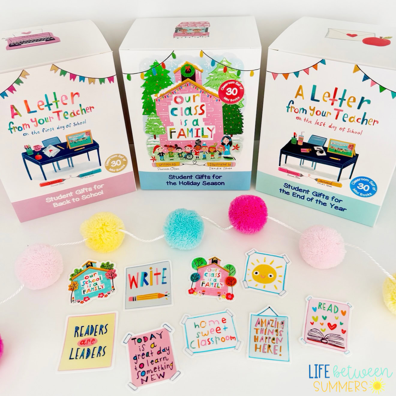 Three decorated gift boxes for students, each labeled for different occasions, are arranged behind colorful pom-poms and cheerful classroom-themed stickers with positive messages. The scene is bright and inviting.